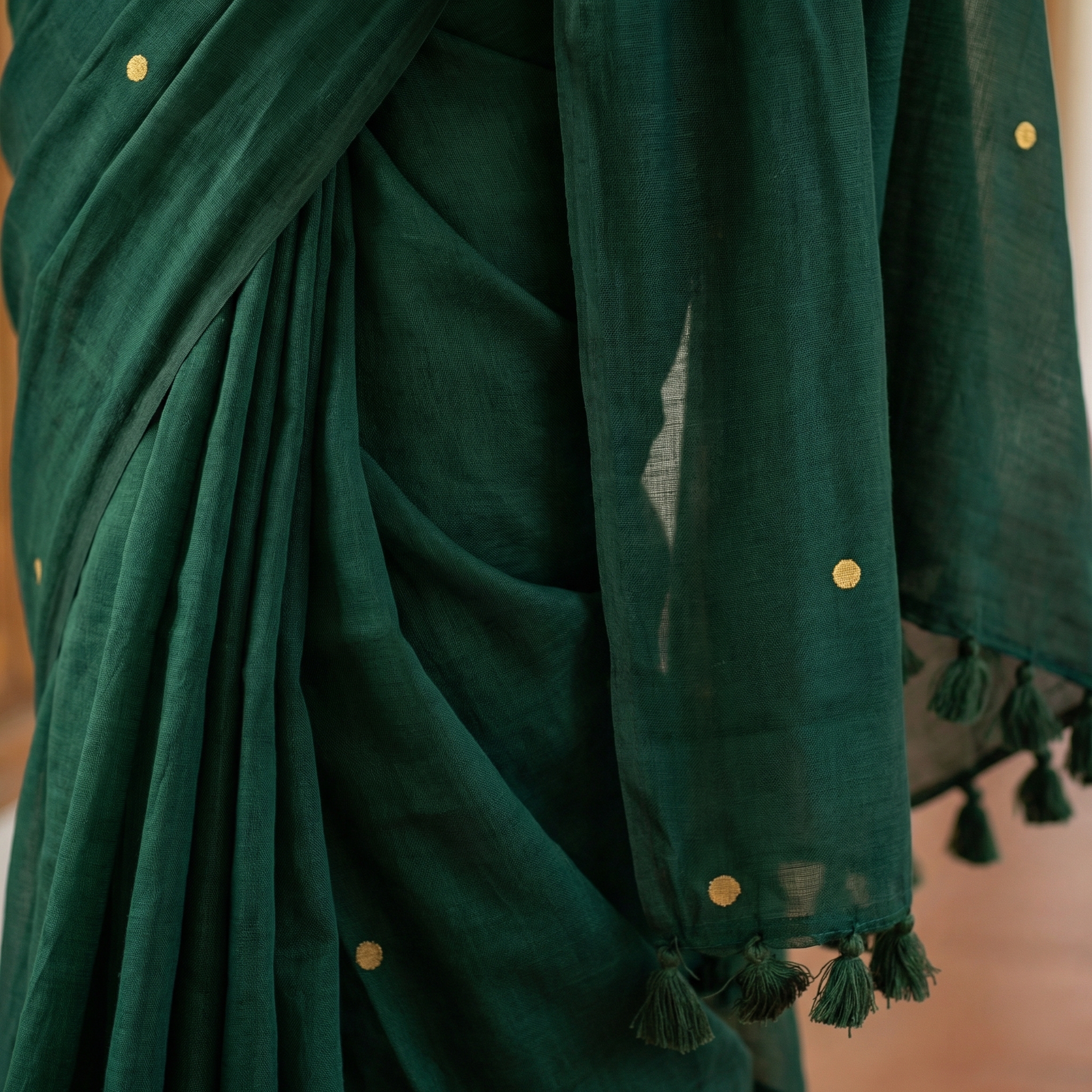 AI-generated close-up product visual of a green saree with gold polka dots and tassels