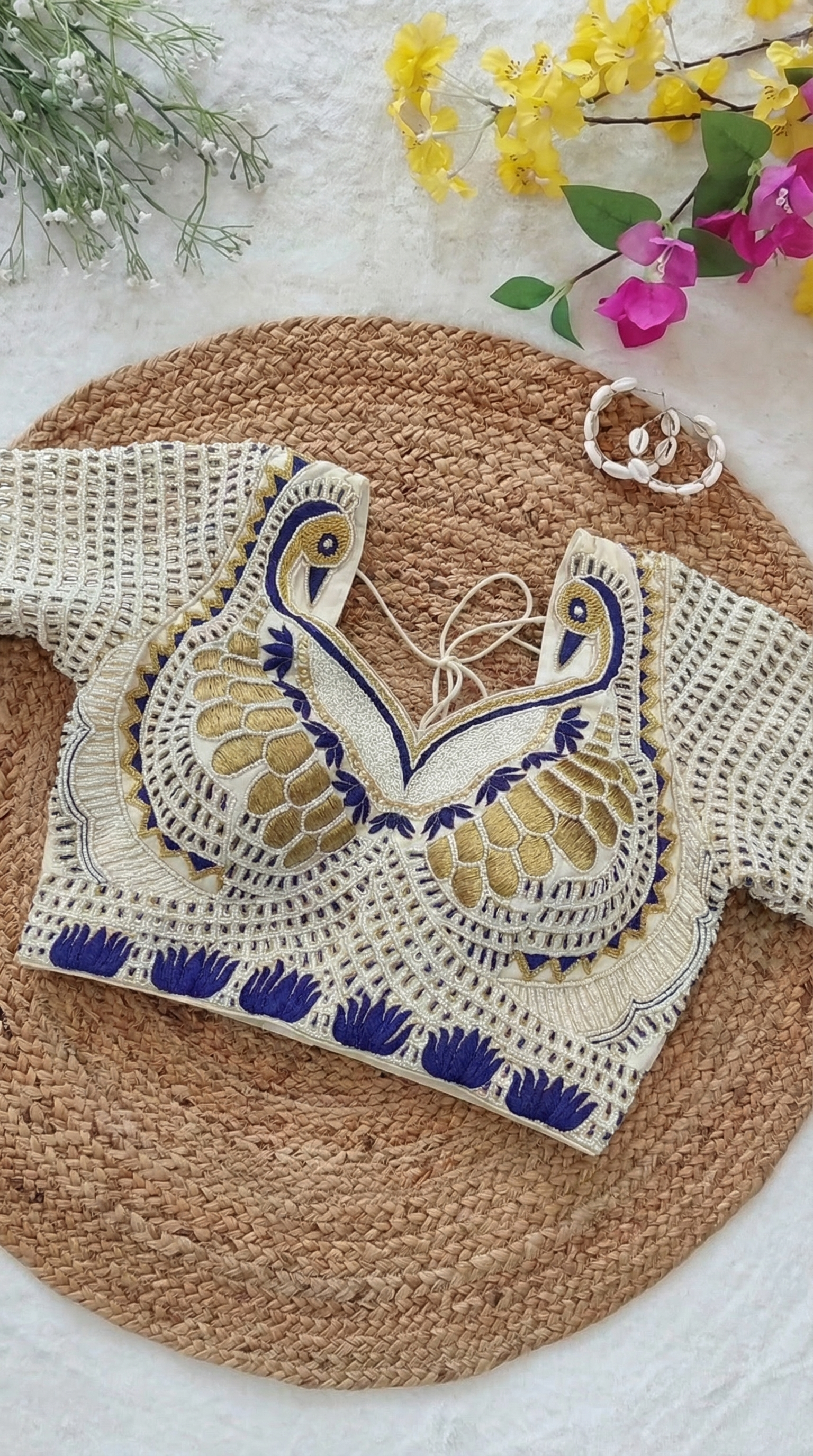 AI-generated product visual of a handwoven peacock-motif blouse styled with flowers
